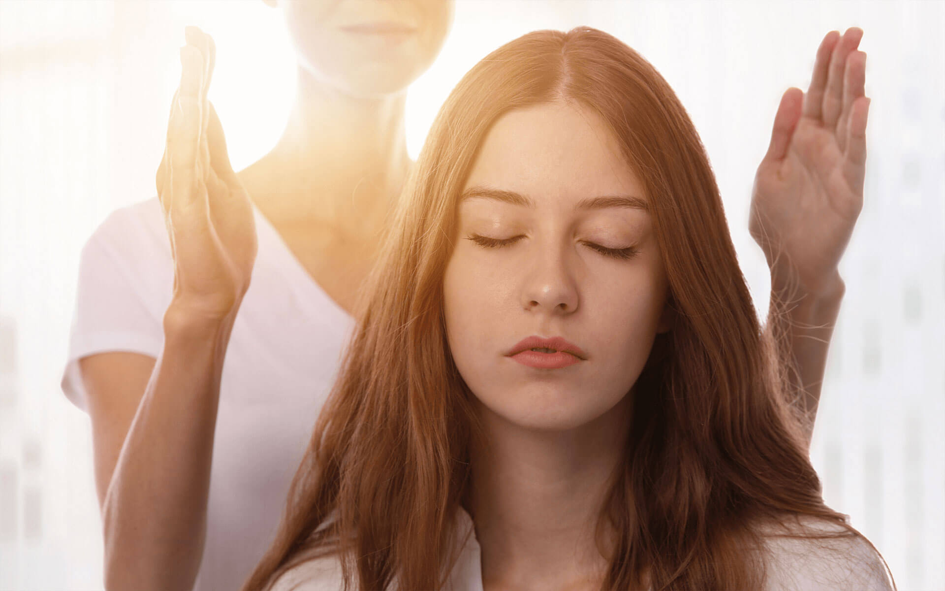 young woman receiving a reiki healing session from another woman 