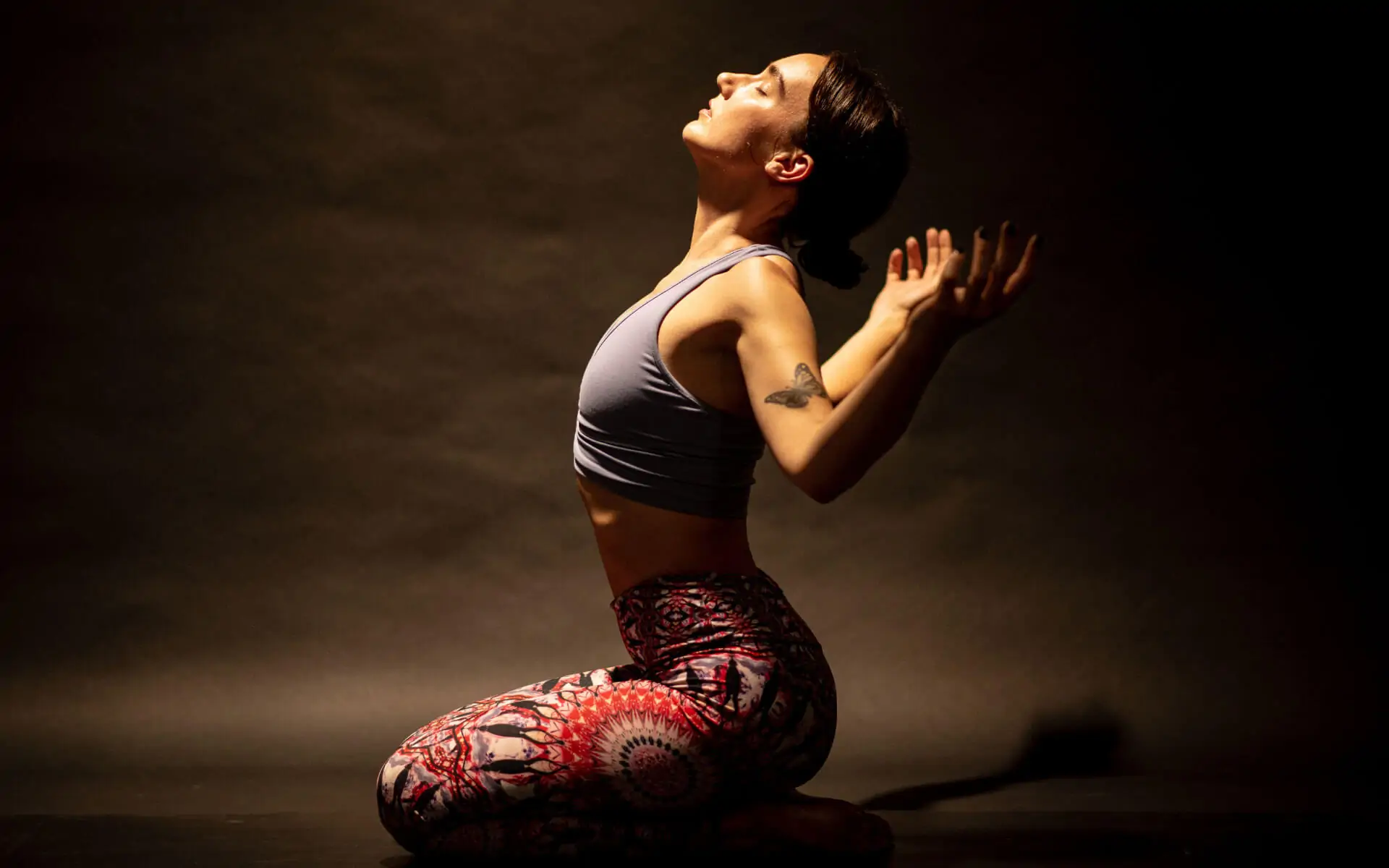 Woman in a heart-opening yoga pose with her face to the light