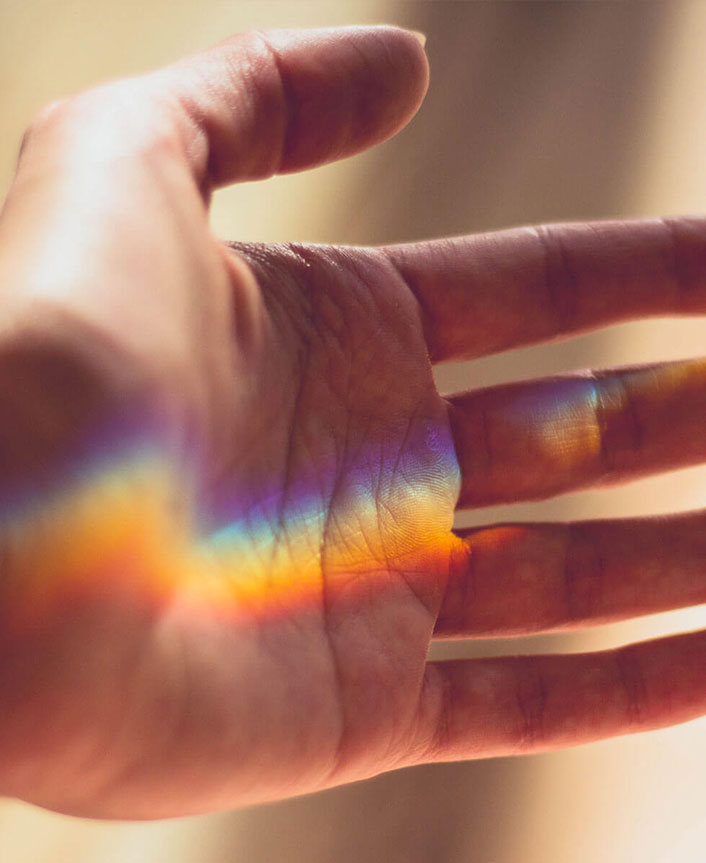 Hand with chakra rainbow colors