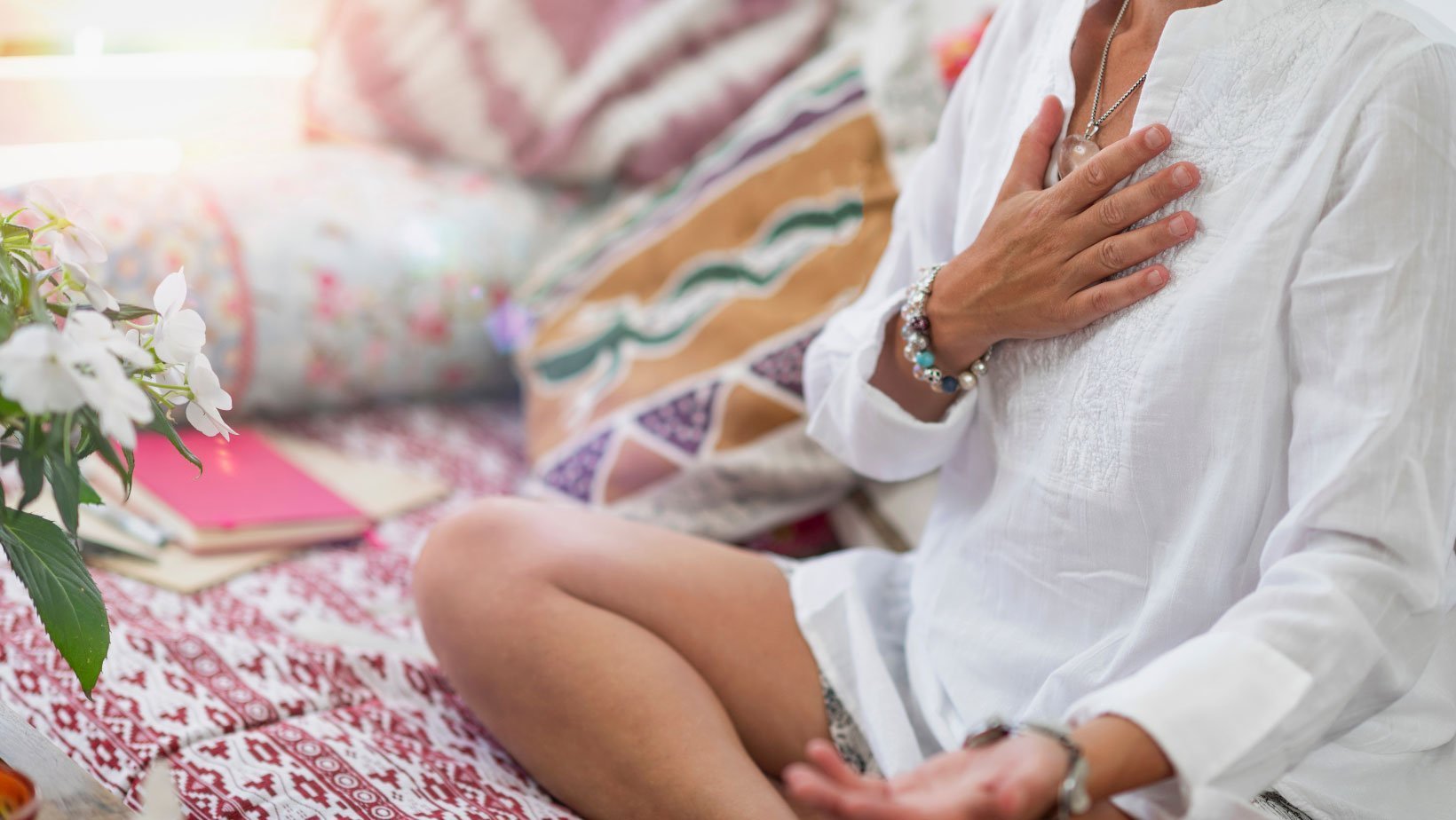 Woman meditating with her hand on her heart